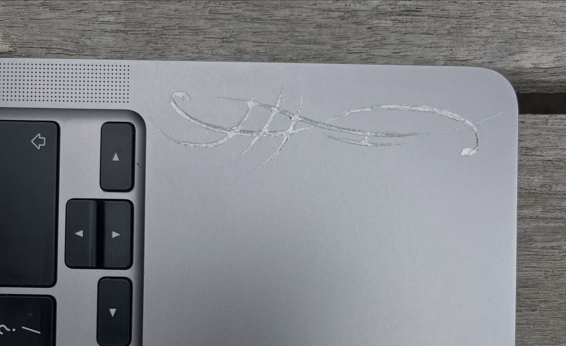 A close view of a pale line drawing scratched beside the laptop keyboard.